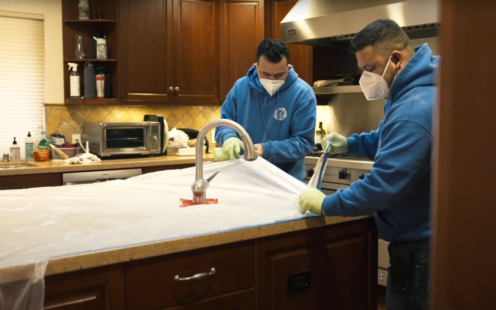 Certified water damage restoration professionals using advanced equipment in Midlothian home Professional water damage restoration technicians working in kitchen with protective equipment and specialized tools